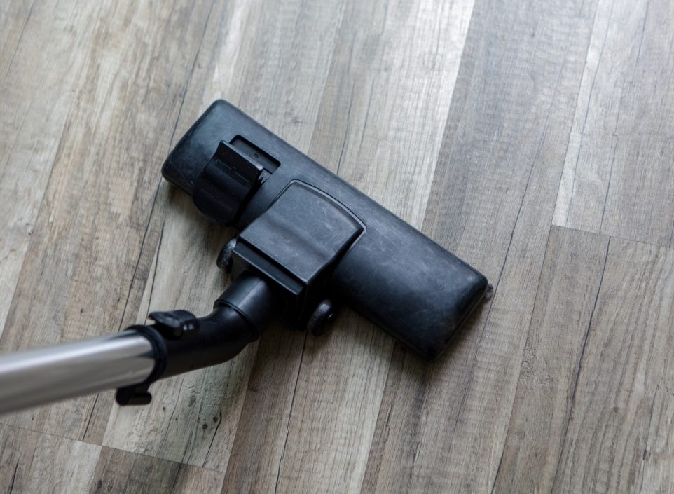 Vacuum cleaner on grey wood floors