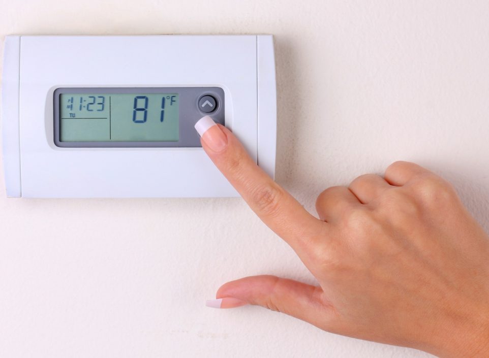 Woman changing thermostat settings